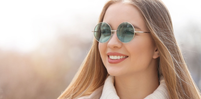 A woman outside wearing blue-tinted eyeglasses