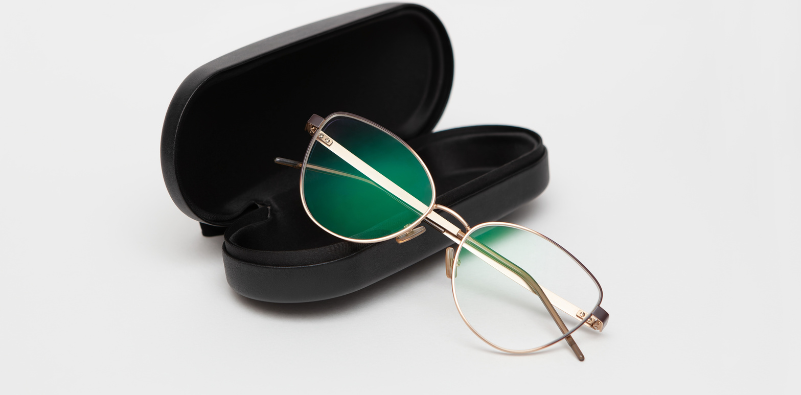 A pair of eyeglasses resting against a black case.