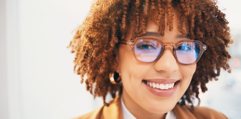 A young woman wearing glasses, smiling