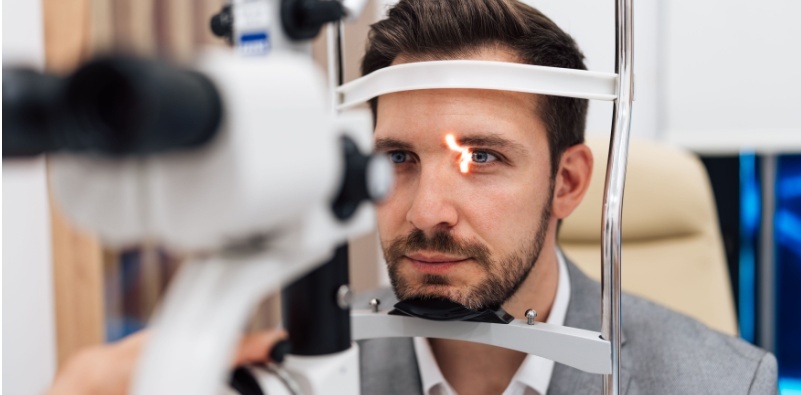 A man undergoing an eye examination at an optometrist's office, receiving a professional vision checkup.