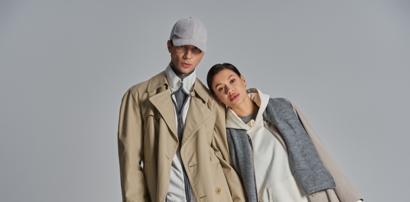 A young, stylish couple in neutral clothing standing side by side