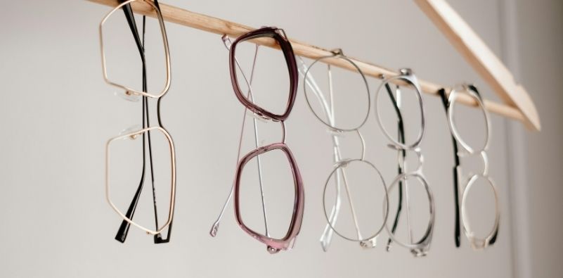 Five different types of glasses hanging from a clothes hanger.
